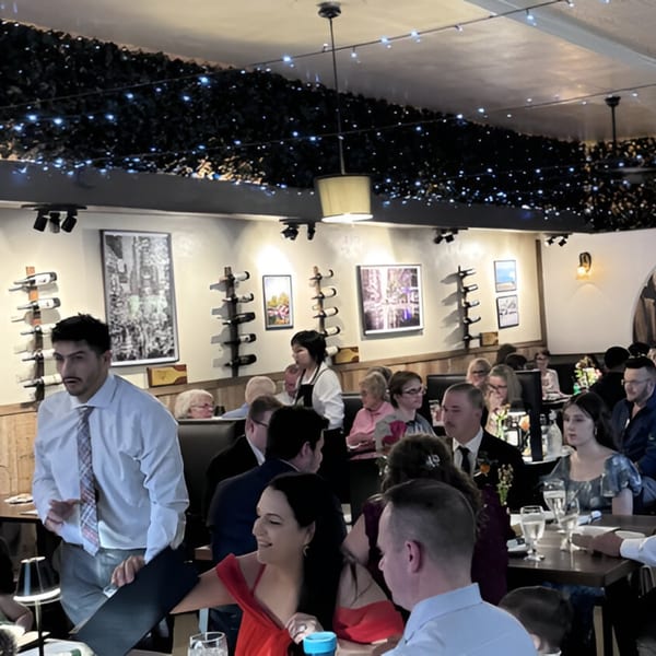 A busy dining room at Volare Restaurant with patrons seated at tables and staff serving.